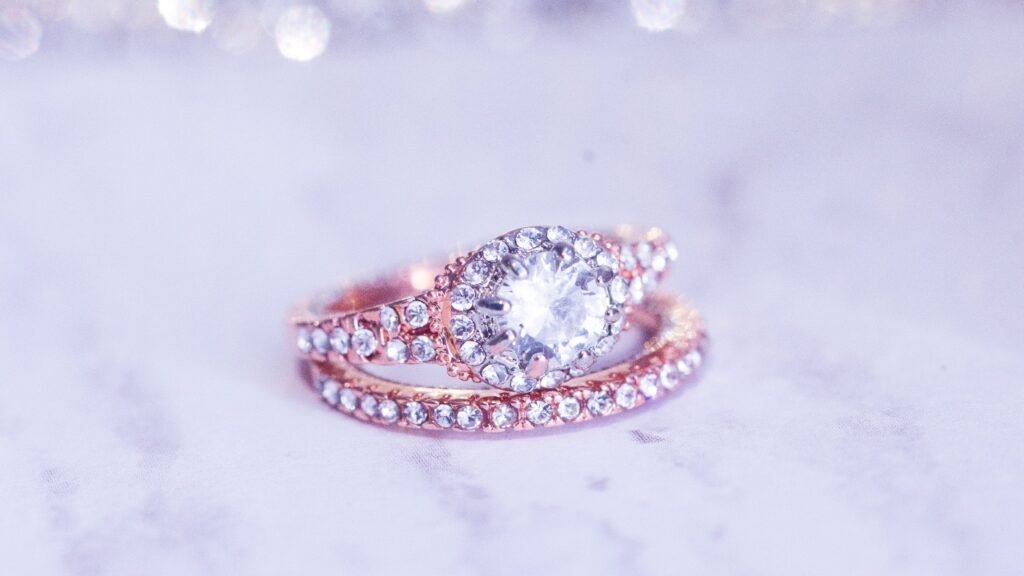 A rose gold ring studded with diamonds being photographed