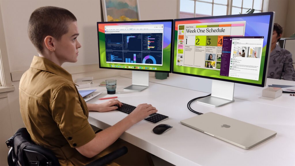 A woman using the Apple MacBook Air M3 connected to two external displays, with the MacBook's lid closed